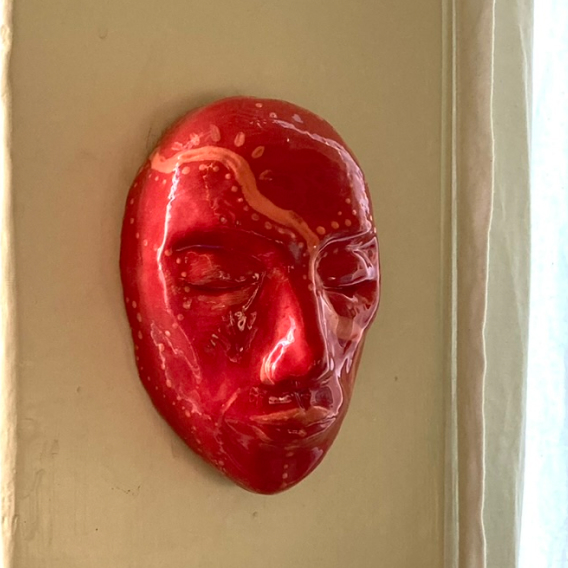 A ceramic mask glazed in red